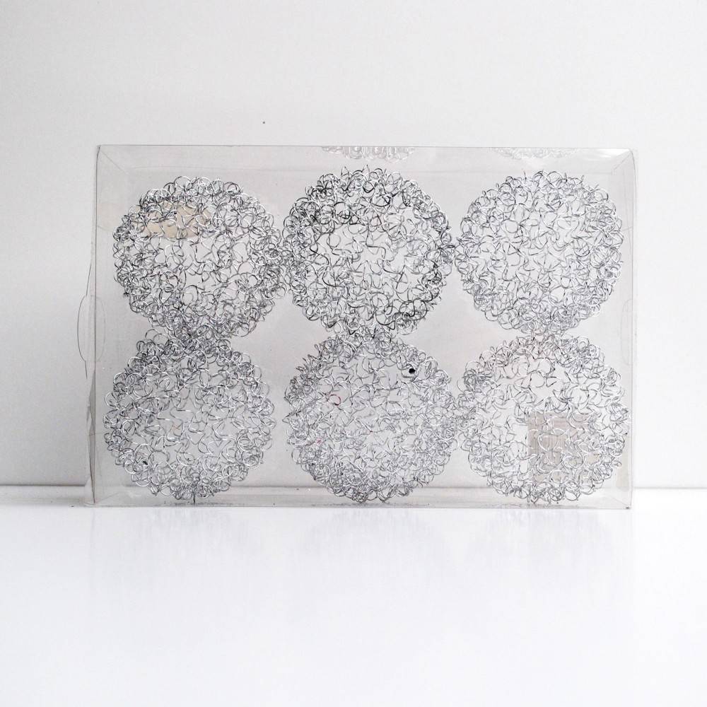 Six round, intricate wire shapes arranged in a clear rectangular box on a white background.