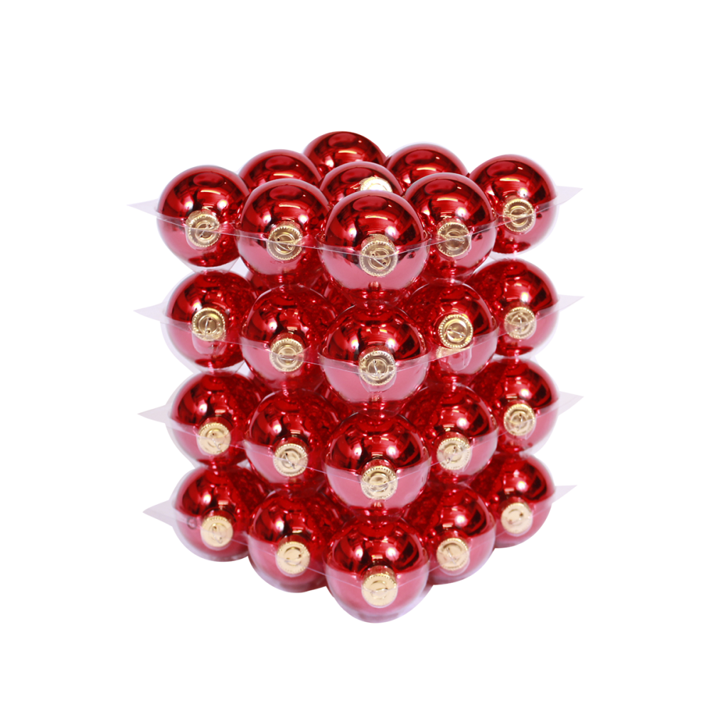 A stacked arrangement of shiny red ornaments with golden caps, reflecting light beautifully.