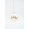 A white ornament with a gold glitter "believe" inscription, hanging from a simple twine.