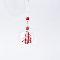 A clear glass ornament with a red and white checkered tree inside, hanging from a string.