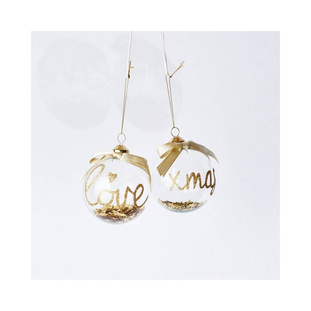 Twee glazen kerstballen met gouden teksten en een strik, gevuld met glitters.
