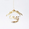 A clear glass ornament with a gold bow and glittery "Xmas" inside.
