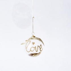 Transparante kerstbal met gouden 'love' tekst en een strikje, hangend aan een dunne draad.