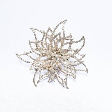 A delicate, shimmering silver flower brooch with intricate petal designs. A delicate, shimmering silver flower brooch with intricate petal designs.