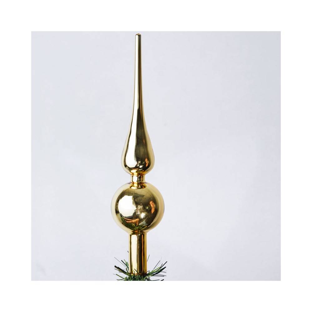 A shiny, gold tree topper with a pointed tip and a round base, reflecting light beautifully.