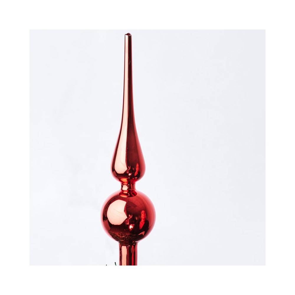A shiny red glass ornament with a pointed top and a round middle, reflecting light beautifully.