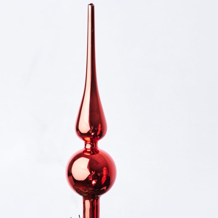 Glanzende, rode kerstboomtopper met een elegante, spitse vorm en een ronde onderkant.