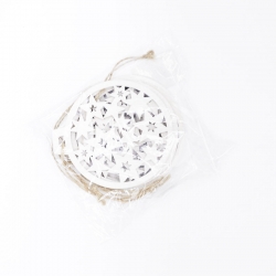 A circular white decoration with intricate star cutouts, packaged with twine.