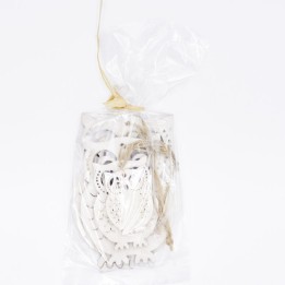 Transparante zak met witte, decoratieve houten figuren en een touwtje voor sluiting.