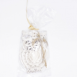 Transparante zak met witte, decoratieve houten figuren en een touwtje voor sluiting.