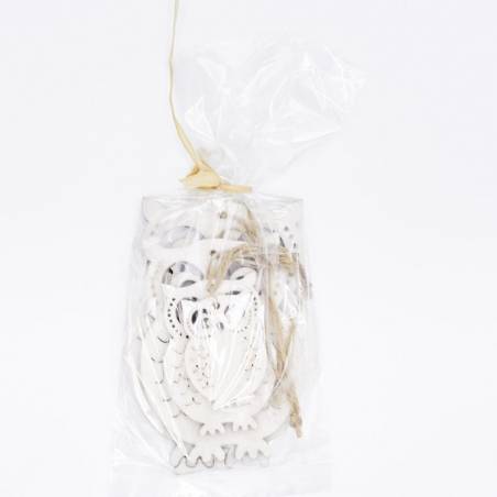 Transparante zak met witte, decoratieve houten figuren en een touwtje voor sluiting.