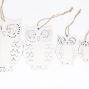 Four white wooden owl decorations with intricate cutouts and twine hangers.