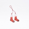 Two small red stockings with white fluffy tops, hanging from a red and white twisted string.