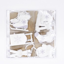 A set of white winter-themed decorations featuring skates, a sled, and cozy boots.