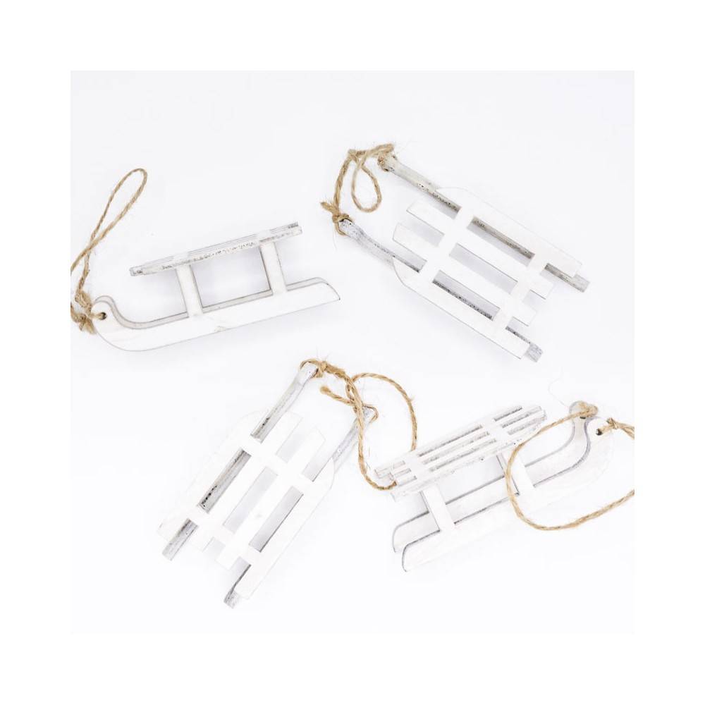 Four small white wooden sleds with twine for hanging, arranged playfully on a white background.