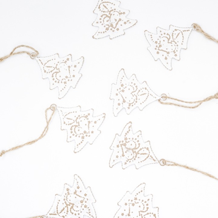 Witte kerstboompjes van papier met gouden details, aan jute touwtjes bevestigd.