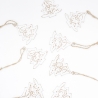 Delicate white paper Christmas trees adorned with golden outlines, strung on twine.