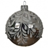 A round, silver ornament with delicate white leaf patterns and a shiny finish.
