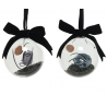 Two glass ornaments with abstract face designs, featuring black and earthy tones and velvet bows.