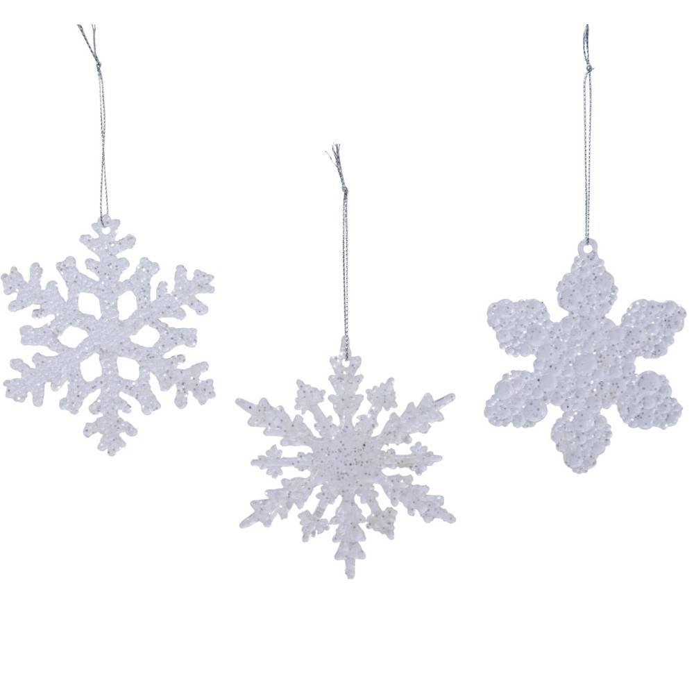 Three white, glittery snowflake ornaments hang, showcasing intricate designs and shimmering surfa...