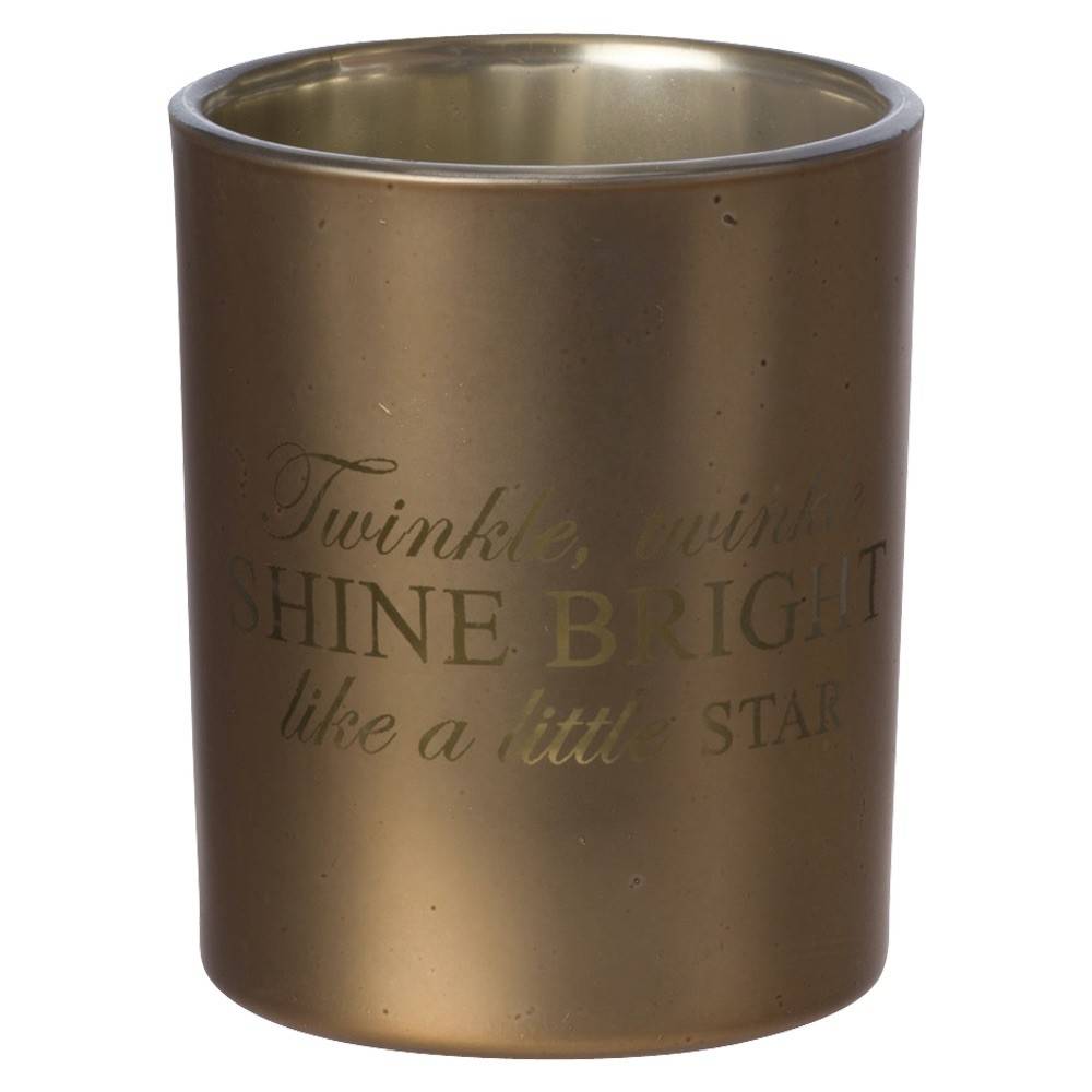 A shiny gold candle holder with an engraved inspirational quote.