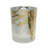 Frosted glass candle holder with golden tree silhouettes and a bird against a soft, misty backgro...