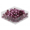 A clear box filled with shiny purple and burgundy decorative beads.