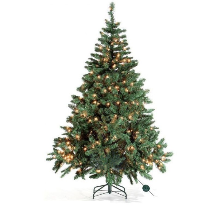 Groene kerstboom met warme lichtjes, kunstmatig en dicht vertakt, op een metalen standaard.