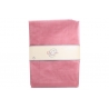 Soft pink fabric neatly folded, wrapped with a simple label in a neutral tone.