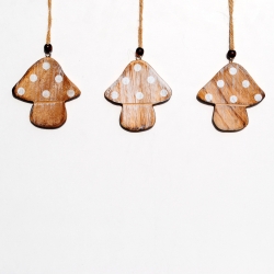 Drie houten paddestoelen met witte stippen, hangend aan een touw op een lichte achtergrond.