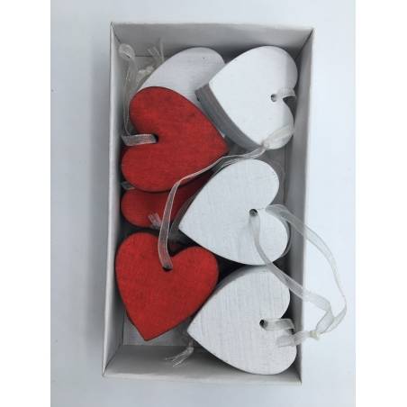 Kleine houten hartjes in wit en rood, met een glanzend lint, netjes in een doos.