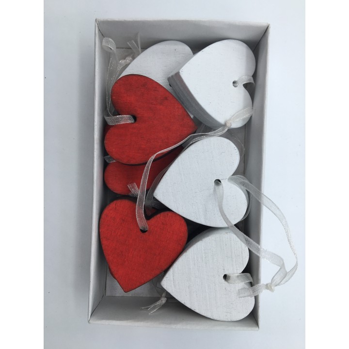 Kleine houten hartjes in wit en rood, met een glanzend lint, netjes in een doos.