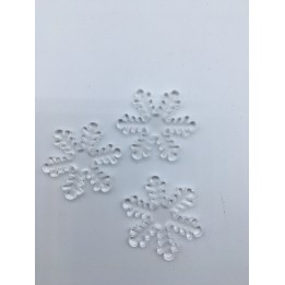 Drie doorzichtige sneeuwvlokken van kunststof liggen op een witte ondergrond.