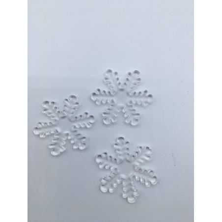 Three delicate, transparent snowflake shapes with intricate patterns on a white surface.
