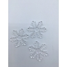 Three delicate, transparent snowflake shapes with intricate patterns on a white surface.