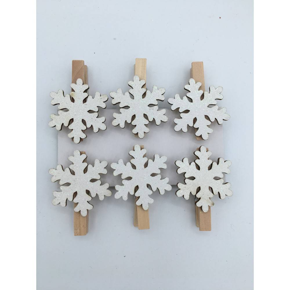Wooden clothespins adorned with white, snowflake-shaped decorations.