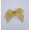 A delicate, shimmering gold ribbon bow with soft, flowing edges.