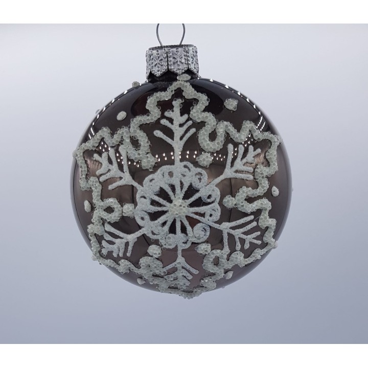 Gouden kerstbal met witte versieringen in een sneeuwvlokpatroon, glanzend en feestelijk.