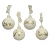 Vier witte kerstballen met gouden teksten: "love", "joy", "xmas" en "believe", aan touwtjes.