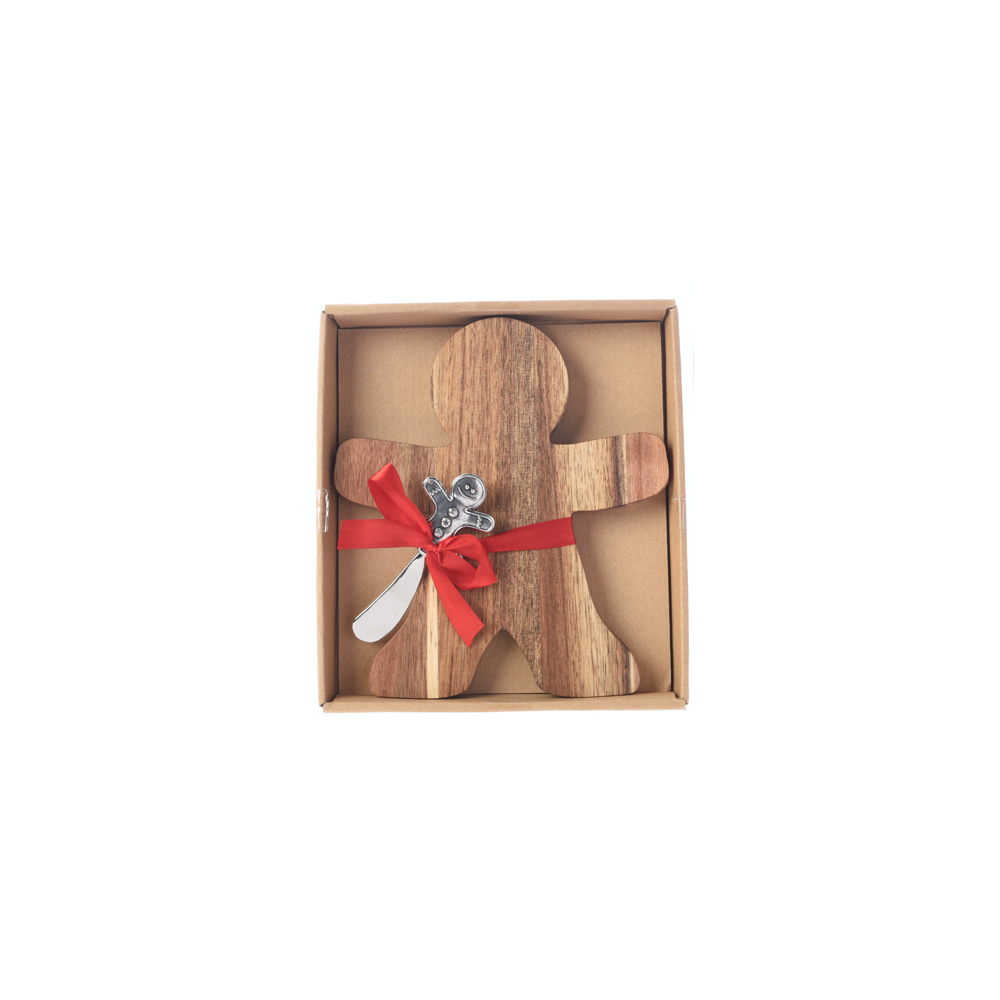 A wooden gingerbread man with a silver spoon, tied with a red ribbon in a box.