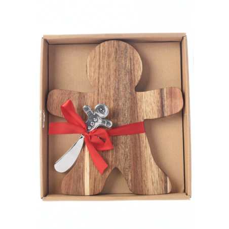 A wooden gingerbread man with a silver spoon, tied with a red ribbon in a box.
