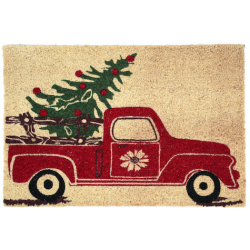 A festive red truck carrying a Christmas tree on a sandy beige doormat.