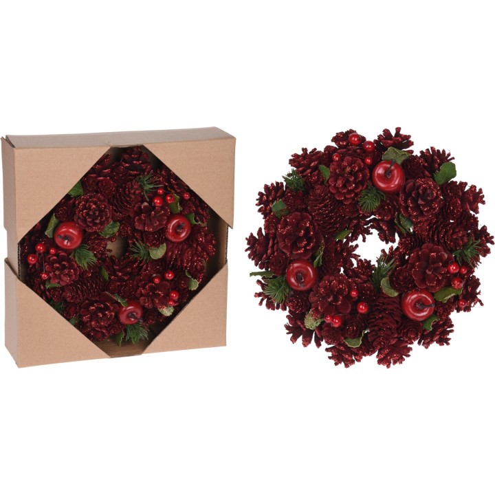 Een rode kerstkrans met dennenappels en glanzende bessen in een kartonnen doos.
