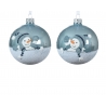 Twee glazen kerstballen met een sneeuwpop, omringd door zilver glitter en een winterse sfeer.