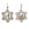 Two wooden snowflake ornaments with cut-out deer and trees, tied with twine and bells.