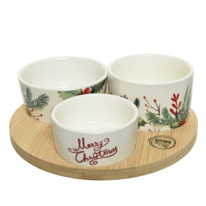 Drie keramische schalen met kerstmotieven op een ronde houten onderzetter.