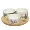 Three decorative ceramic bowls with festive greenery on a wooden tray.