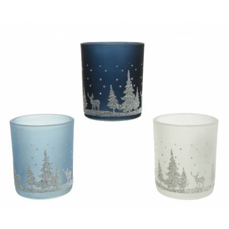Three frosted glass candle holders in blue, navy, and white, adorned with snowy forest scenes.