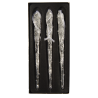 Three elongated, transparent glass icicles with a textured surface, set against a black background.