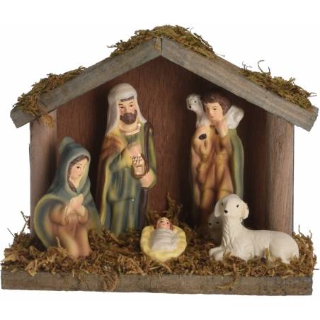 Een kerststal met figurines van Maria, Jozef, het kindje Jezus en een schaap, omgeven door mos.
